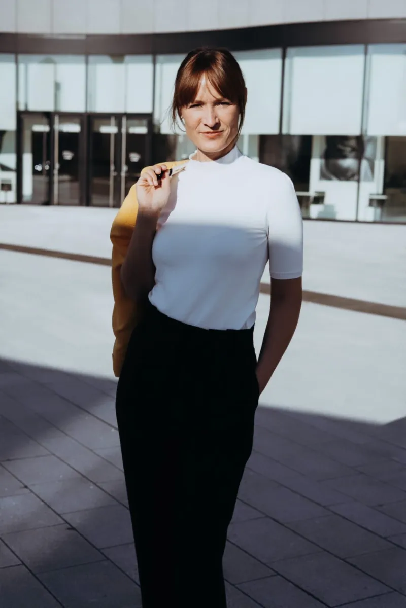 Frau trägt lässig Blazer über der Schulter