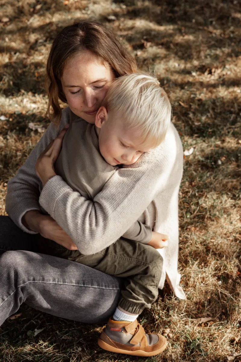 Mutter umarmt ihren Sohn auf ihrem Schoß