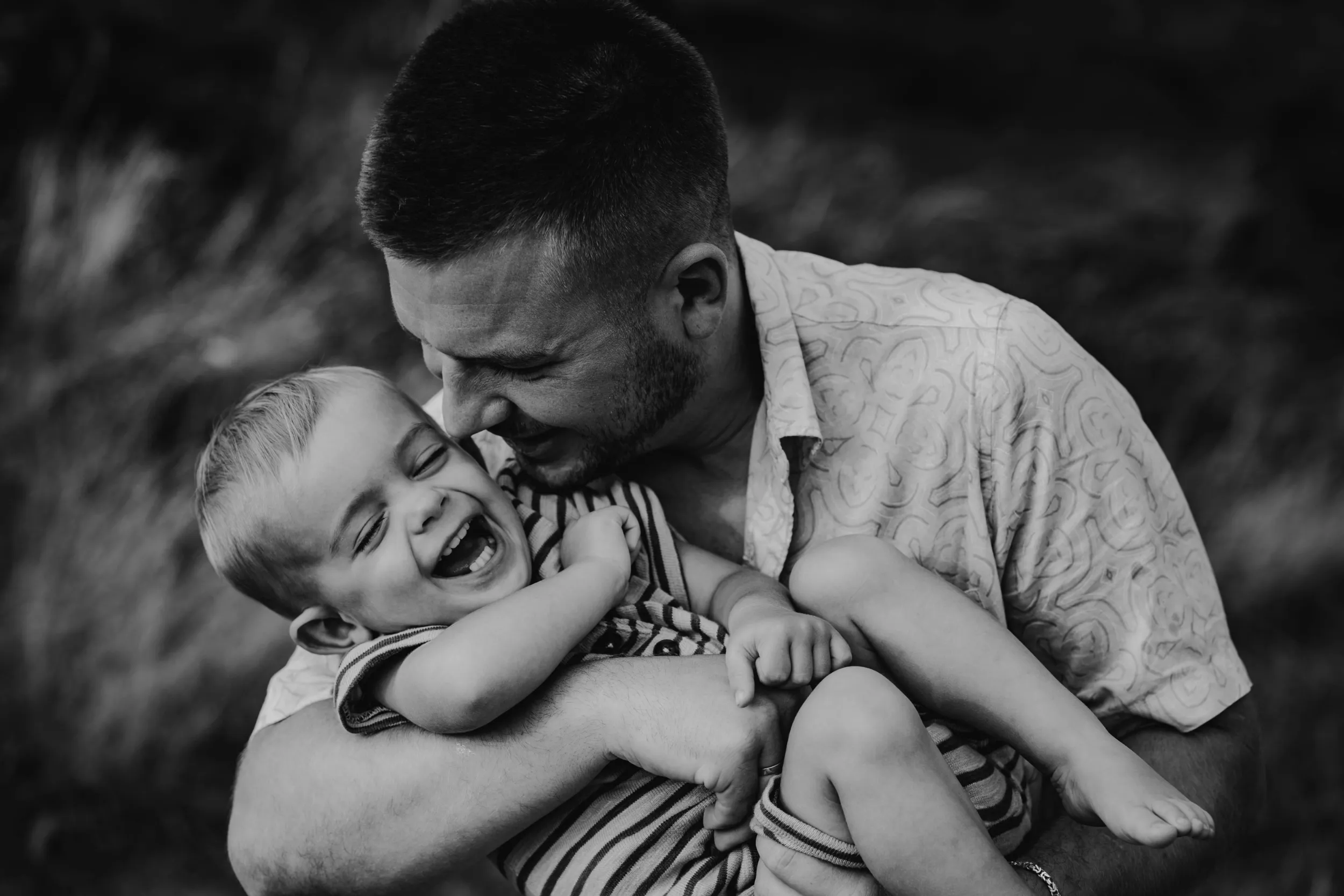 Papa kitzelt kichernden Sohn