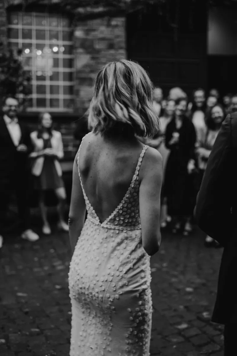 Rückansicht Braut steht vor ihren Gästen