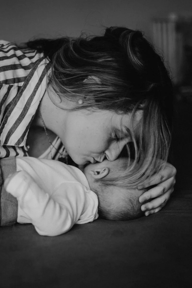 Mutter küsst ihr Neugeborenes