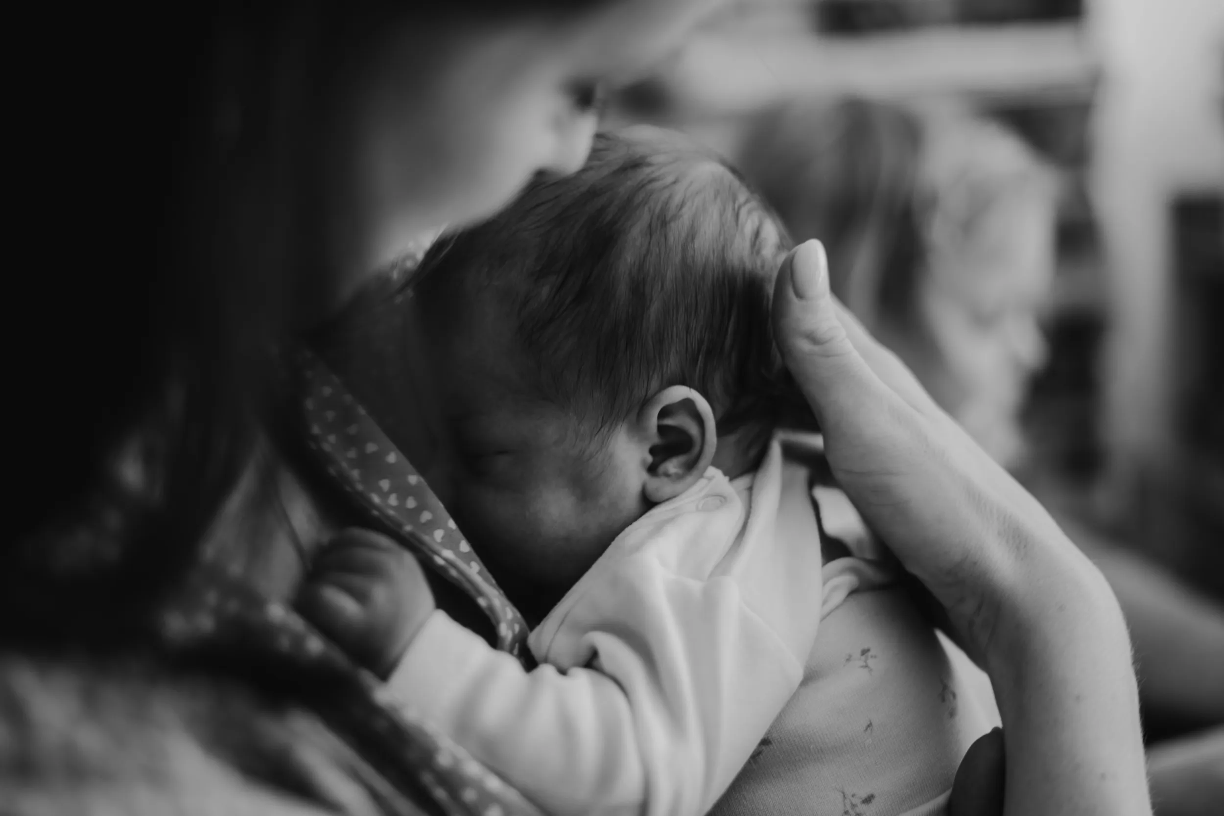 Mama hält ihr Neugeborenes ganz nah