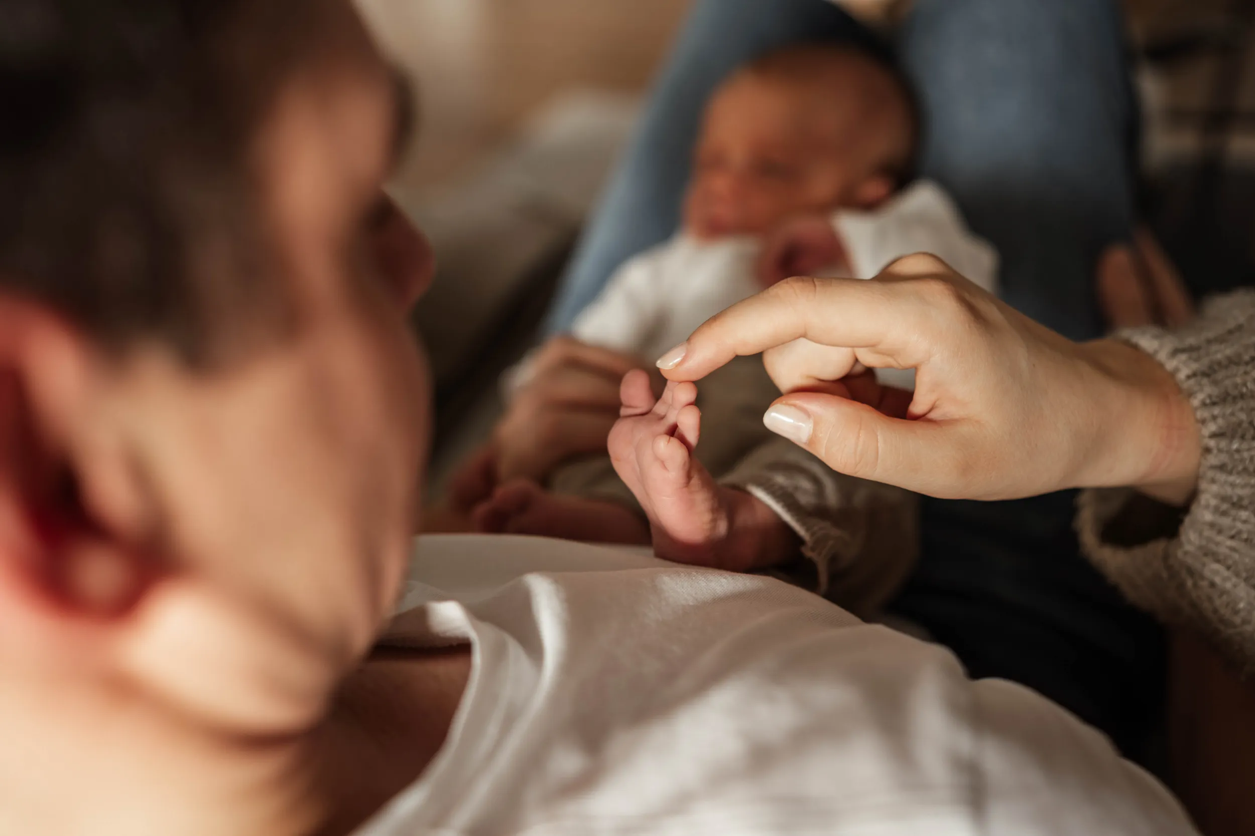 Papa mit Neugeborenem auf dem Schoß