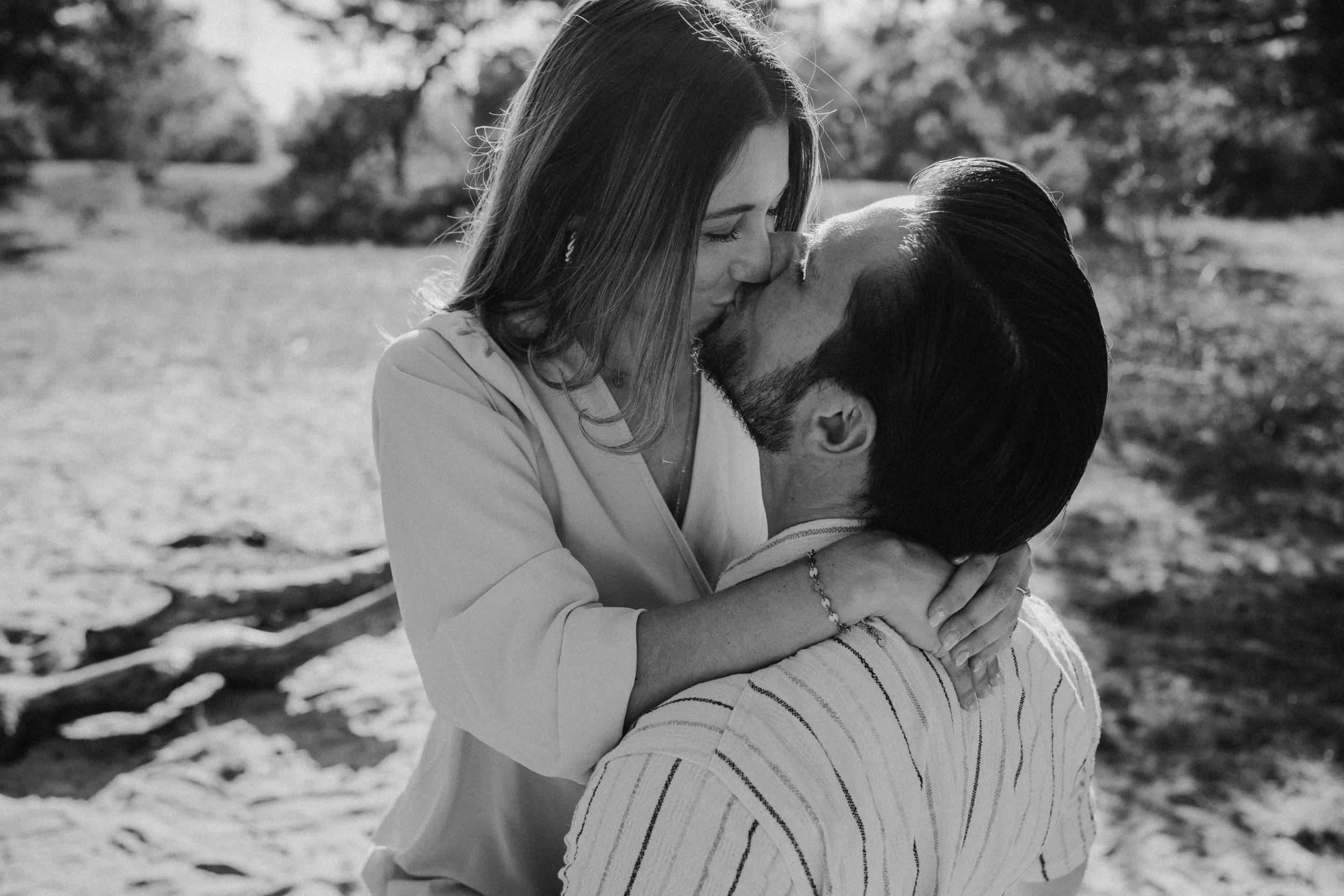 Paar küsst sich draußen im Sonnenschein